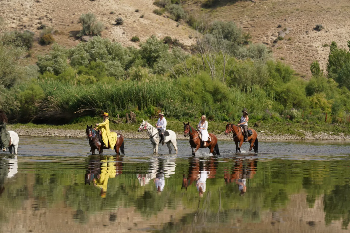 Riders crossing a river on horseback